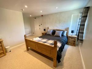 a bedroom with a wooden bed in a room at The Maltsters Country Inn in Badby