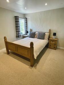 a bedroom with a wooden bed and a window at The Maltsters Country Inn in Badby