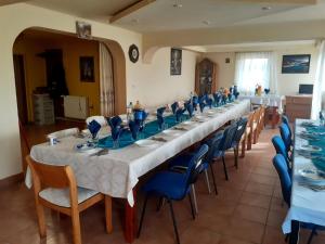 a long table in a room with blue chairs at Pensiunea Iza in Bradu