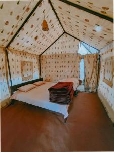 um quarto com uma cama numa tenda em Sangam River camp em Sissu