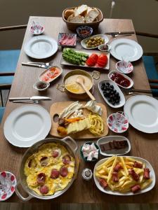 una mesa de madera con platos y comida. en Hayde Bungalow en Çamlıhemşin
