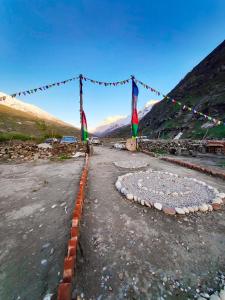a large circle in the middle of a road with flags at Sangam River camp in Sissu