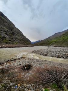 a river in the middle of a mountain at Sangam River camp in Sissu