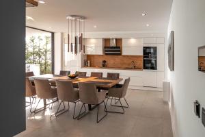 a kitchen and dining room with a wooden table and chairs at Villa Trinity - Hillside villa with Sea View and Infinity Pool in Kali
