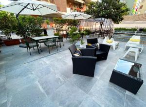 un patio avec des chaises, des tables et des parasols dans l'établissement Hotel Franchi, à Florence