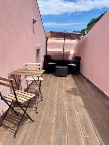 a patio with a table and chairs and an umbrella at Douro Afurada Boutique Apartments in Vila Nova de Gaia