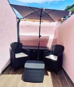 a patio with two chairs and an umbrella at Douro Afurada Boutique Apartments in Vila Nova de Gaia