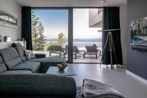 a living room with a couch and a large window at Villa Trinity - Hillside villa with Sea View and Infinity Pool in Kali