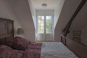 ein Schlafzimmer mit einem Bett und einem großen Fenster in der Unterkunft Domaine Les Maurelles in Milhac