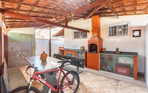 a bike parked in a room with a kitchen at Casa aconchegante à 200m da praia in Rio das Ostras