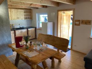 a kitchen with a wooden table and a kitchen with a refrigerator at Domki Kaktus in Osieki