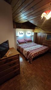 a bedroom with a bed and a wooden ceiling at Mansarda dell'orso in Falcade