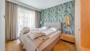 um quarto com uma cama com uma parede verde em Apartamenty Sun & Snow Nabrzeże Yacht Park em Gdynia
