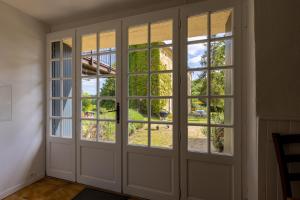 Zimmer mit Türen und Fenstern mit Aussicht in der Unterkunft Domaine Les Maurelles in Milhac