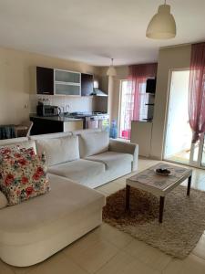 a living room with a white couch and a coffee table at Antalya Guest Home in Antalya