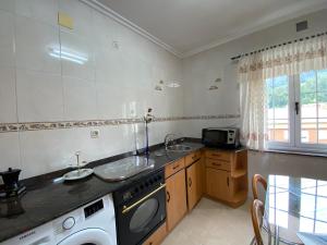 a kitchen with a sink and a washing machine at Casa Elsa in Torrelavega
