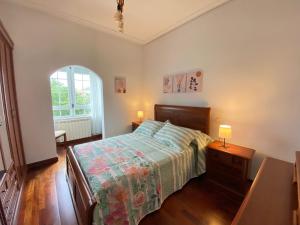 um quarto com uma cama e uma mesa com 2 candeeiros em Casa Elsa em Torrelavega