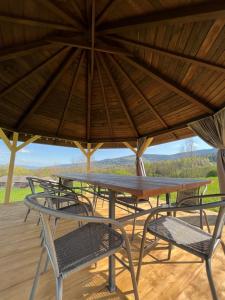 une table et des chaises en bois sous un grand parasol dans l'établissement Agroturystyka Liana, à Polanica-Zdrój