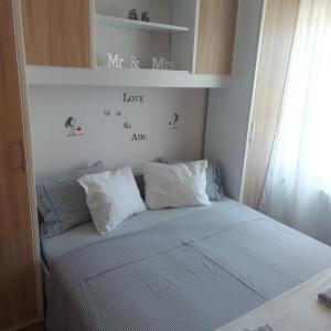 a bed with two pillows on it in a bedroom at Apartment San in Ližnjan