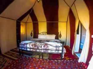 a bedroom with a bed in a room at Morocco tours camp in Merzouga