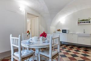 a kitchen and dining room with a white table and chairs at Le Stanze Del Poeta - SIT Rooms in Lecce