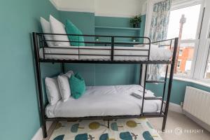 two bunk beds in a room with blue walls at Beautiful and Stylish 3Bedroom Flat with Parking - Beaufort Heights in Iford