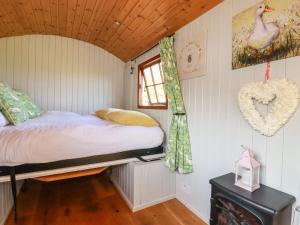 a small bedroom with a bed and a window at Puddle Duck Shepherds Hut in Launceston