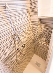 una doccia con soffione in un bagno di Hotel Byron solo per giovani a Riccione