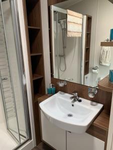 a bathroom with a white sink and a shower at Tide Away Anderby Creek in Anderby