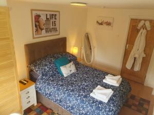 a small bedroom with a bed with a blue comforter at Exclusive use of Garden Room!! in Bristol