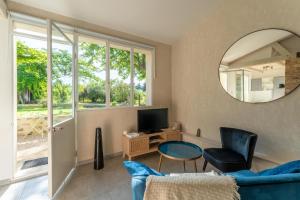 a living room with a blue couch and a mirror at Studio à la campagne in Sarrians