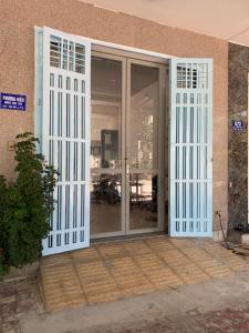 una entrada a un edificio con puertas blancas en Nhà nghỉ PHƯƠNG HIỀN, en Vung Tau