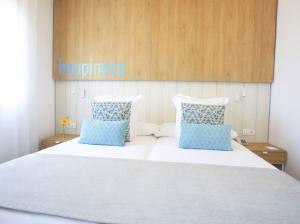 a bedroom with a large bed with blue pillows at Labranda Alyssa Suite Hotel in Playa Blanca