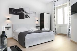 una camera da letto bianca con un letto grande e uno specchio di Il Piccolo Principe ad Alghero