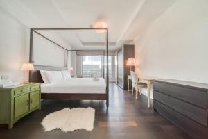 1 dormitorio con cama blanca, escritorio y escritorio en Limestone House, Dubai International Financial Centre - Mint Stay, en Dubái