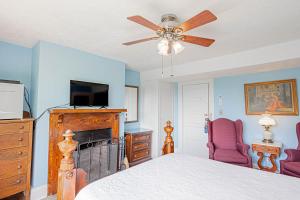 1 dormitorio con 1 cama y ventilador de techo en Echo Mountain Inn en Hendersonville