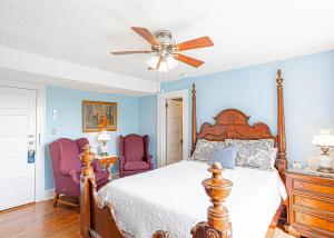 a bedroom with a bed and two purple chairs at Echo Mountain Inn in Hendersonville