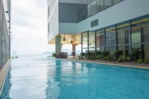 芽庄Moonlight Bay Panorama Condotel Ocean View的建筑物前的游泳池