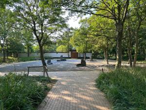 um caminho num parque com árvores e um edifício em Home away from home em Oostende