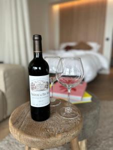 uma garrafa de vinho e um copo de vinho numa mesa em Home away from home em Oostende