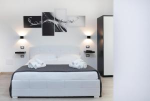 una camera da letto con un letto bianco e due asciugamani di Il Piccolo Principe ad Alghero