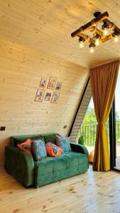 a green couch in a room with a wooden ceiling at Magical space Tsikhisdziri in Tsikhisdziri