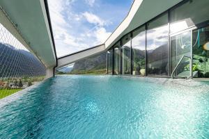 a large swimming pool in a building with windows at Lifesteil Aparthotel in Umhausen