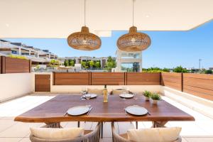 a wooden table and chairs on a patio at Jardiana Lotus - Walking distance to La Cala De Mijas in La Cala de Mijas