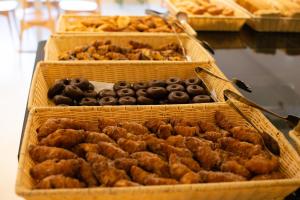 a bunch of different types of donuts in baskets at Hotel Cala Font in Salou