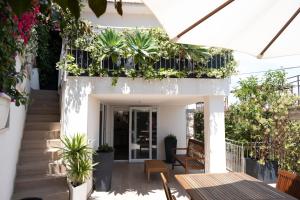 a patio with tables and potted plants on a building at Teatro Apartments Mondello in Palermo