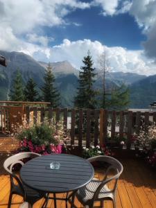 una mesa y sillas en una terraza con vistas a las montañas en Hotels Les Catrems & Le Montagnou en Orcières
