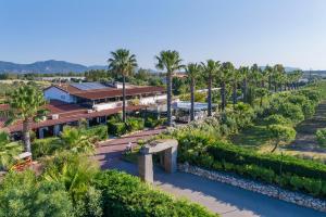 uma vista aérea de um resort com palmeiras em Hotel Rurale Orti di Nora & SPA em Santa Margherita di Pula