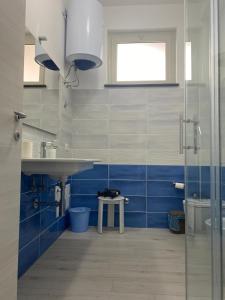 baño azul y blanco con lavabo y aseo en CADORNA, en Santa Maria del Cedro