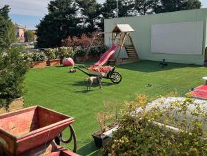 a dog standing in a yard with a playground at WellHome Asti Premium Apartments with Private Terrace & Garden in Asti